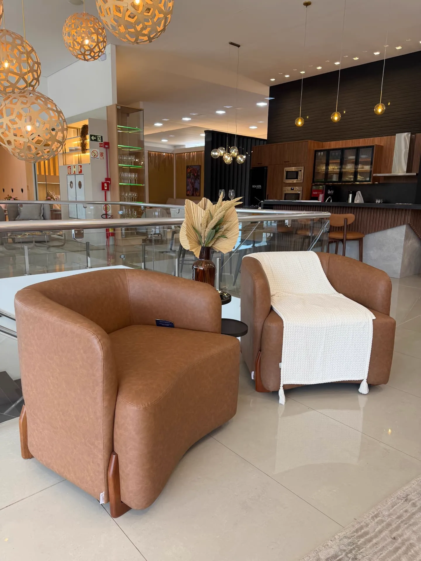 Lounge do showroom com poltronas em couro caramelo